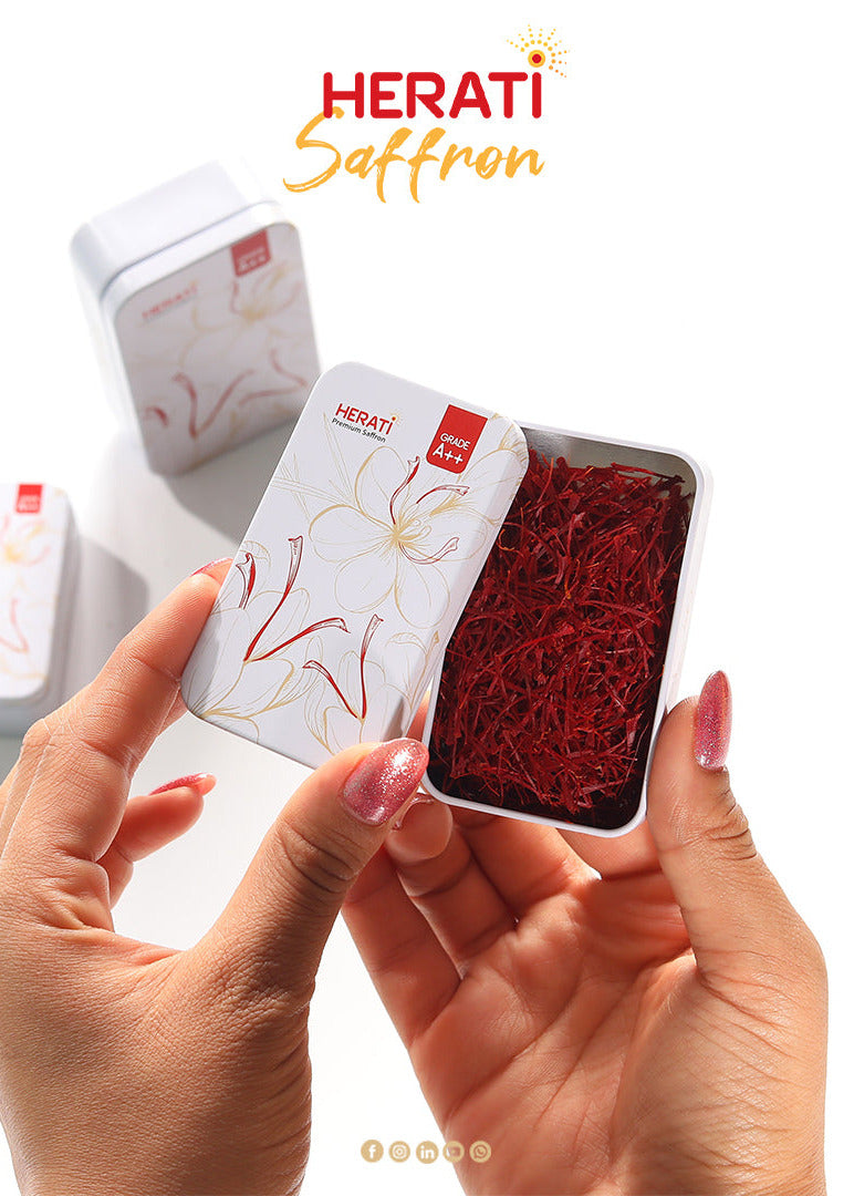 Hands holding a small tin of Herati Saffron with visible saffron strands.