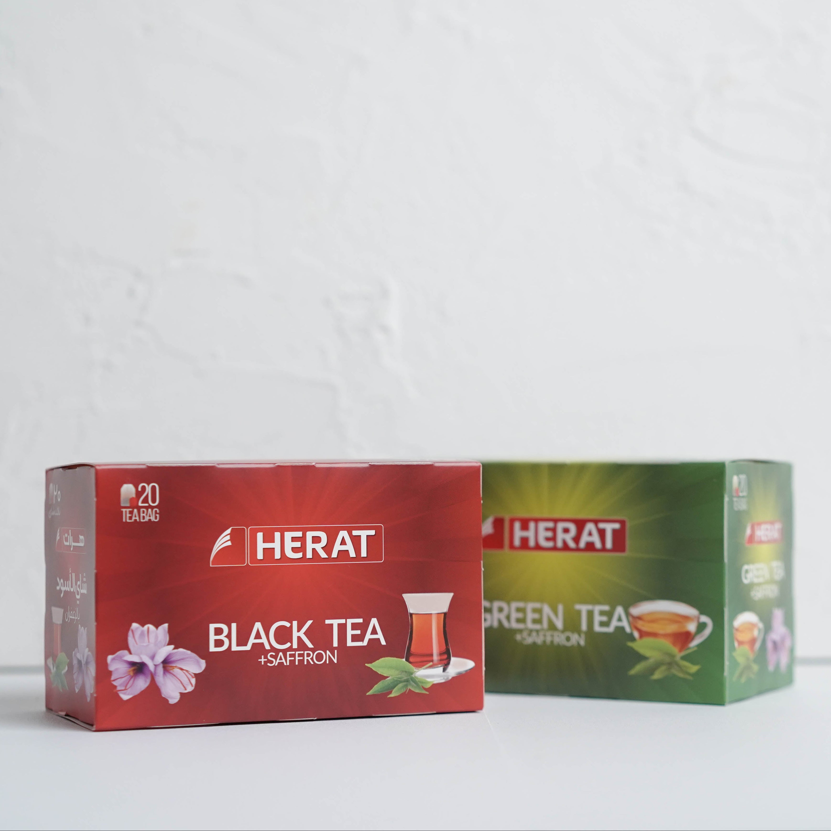 Two boxes of Herat tea, one black tea and one green tea, on a white background.