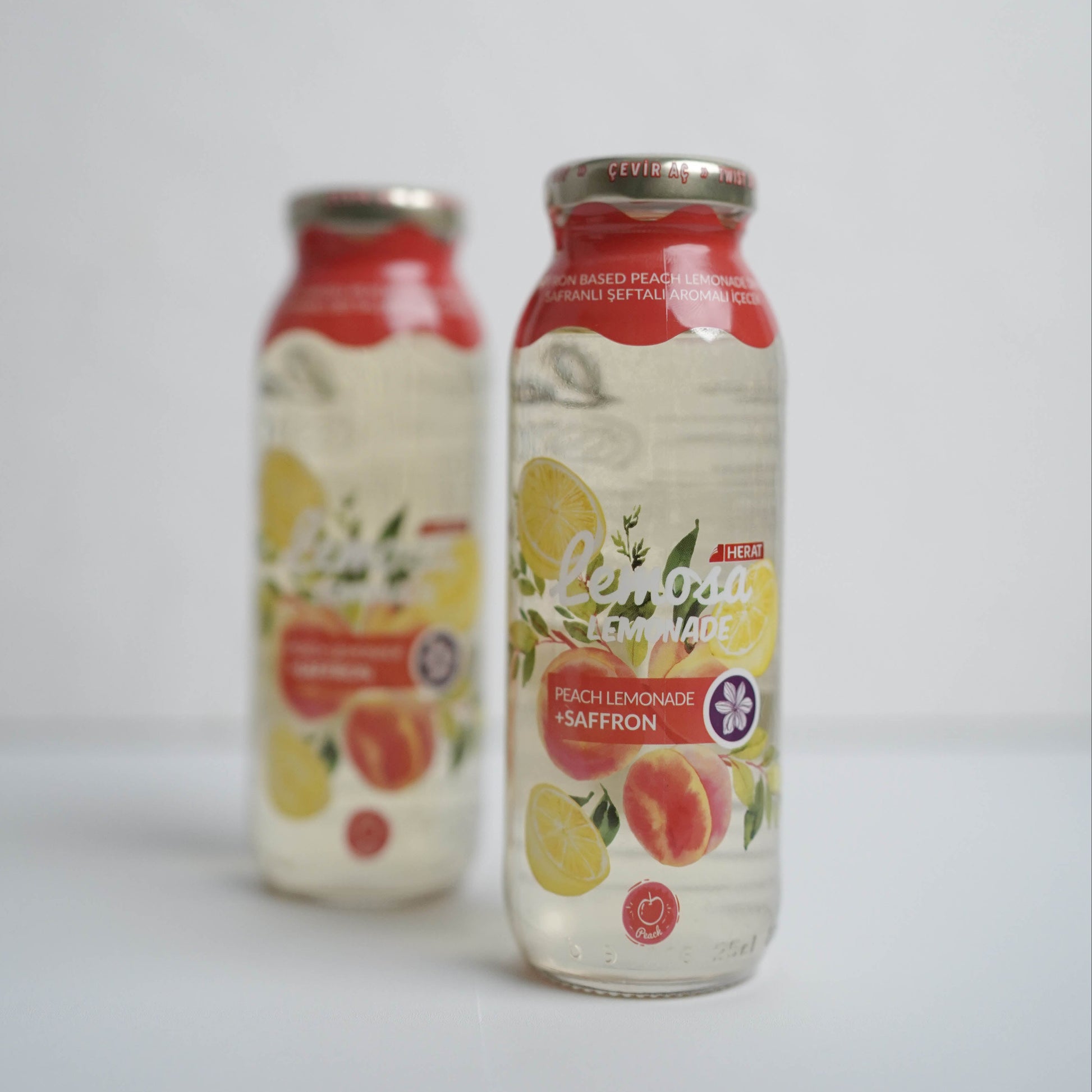 Two bottles of juice with fruit illustrations on a white background
