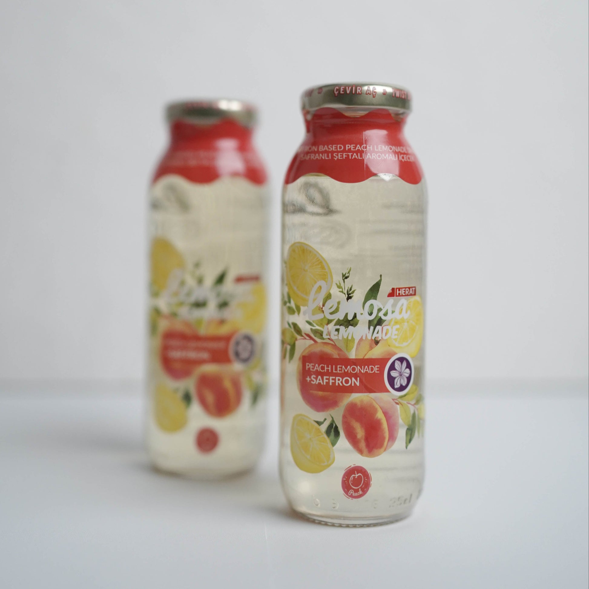 Two bottles of juice with fruit illustrations on a white background