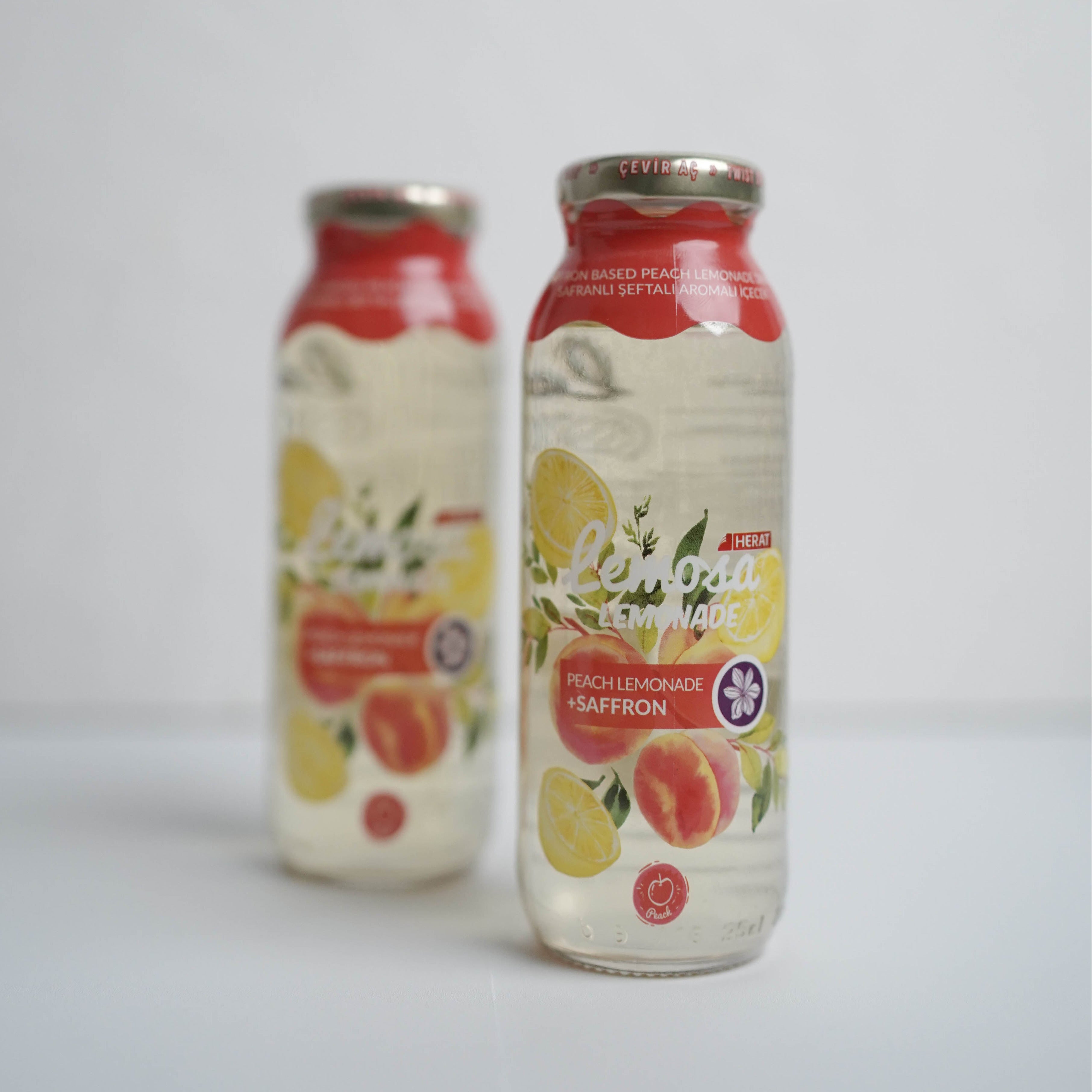 Two bottles of juice with fruit illustrations on a white background
