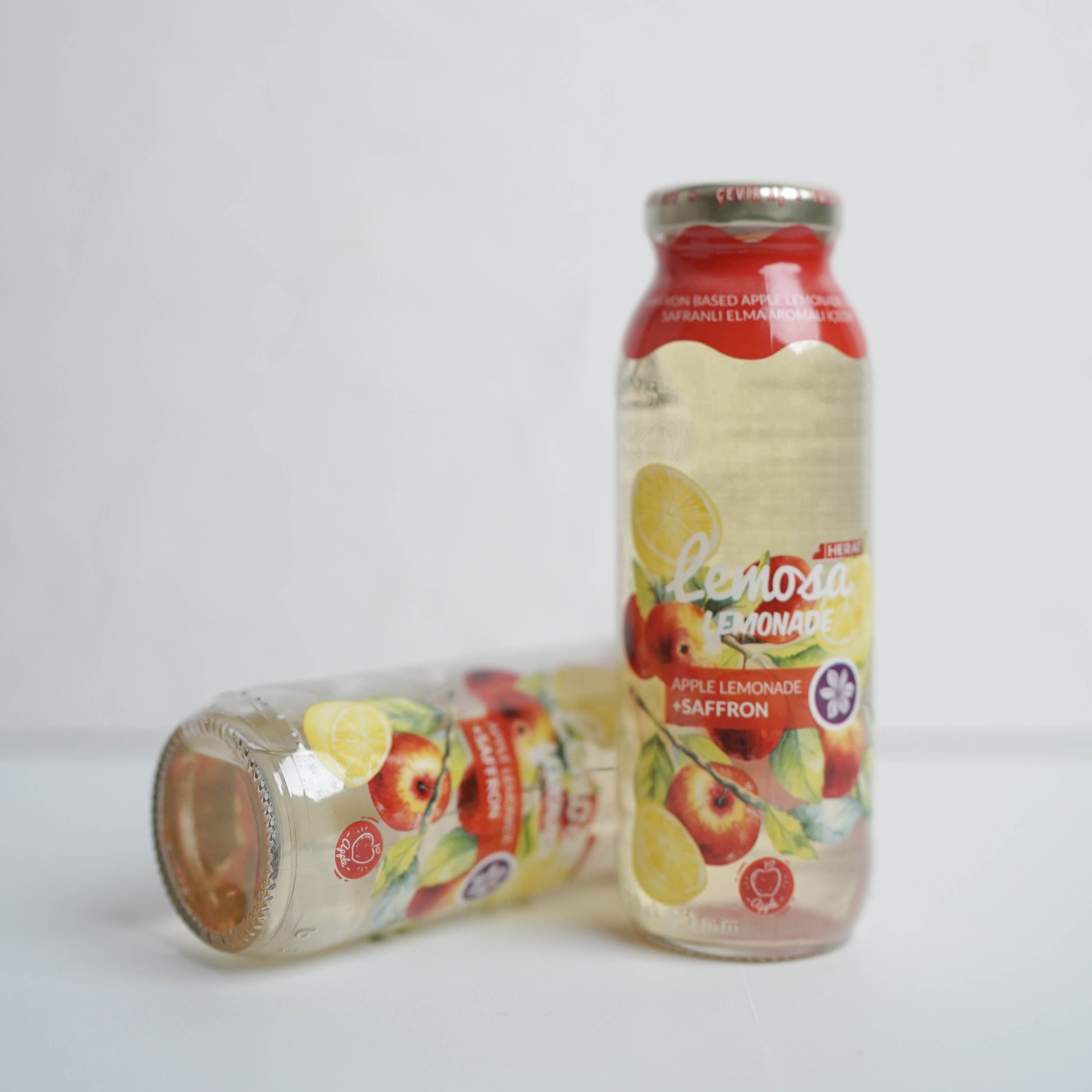 Two glass jars with fruit-themed labels on a light gray background