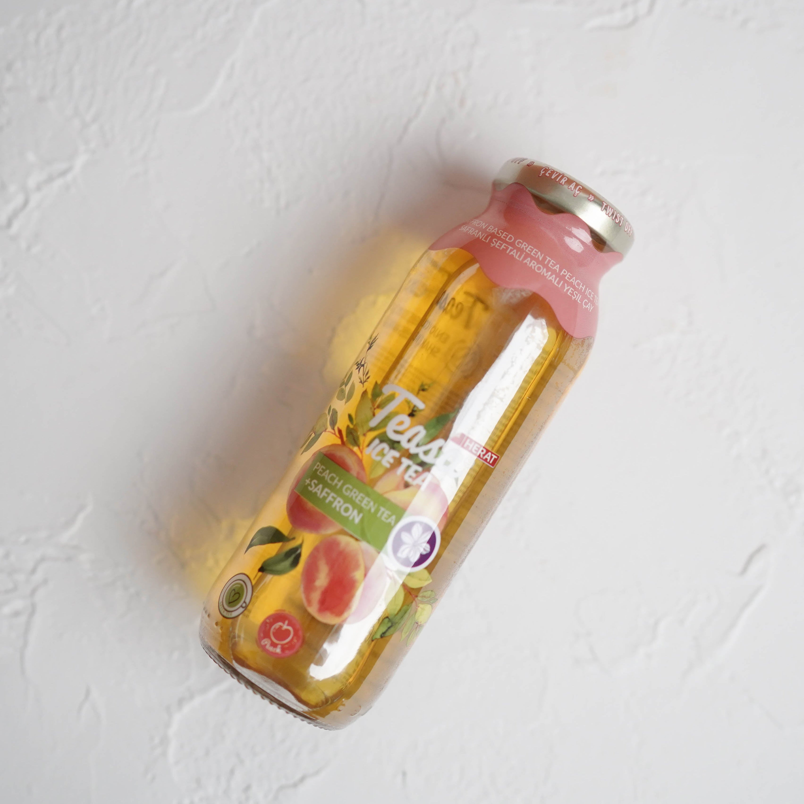 Bottle of juice with a floral label on a light gray background