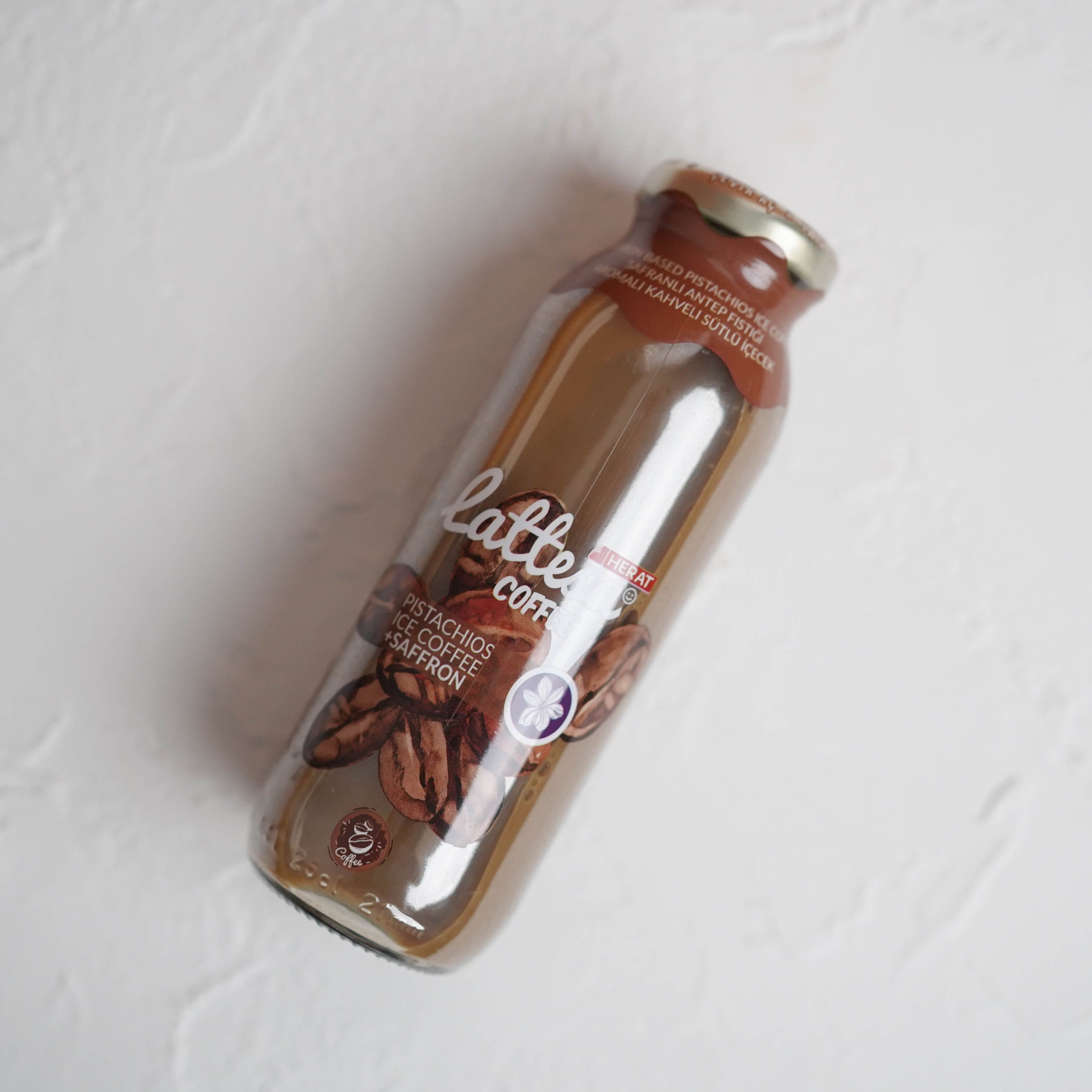 Glass bottle with coffee beans and 'latte' label on a light gray background