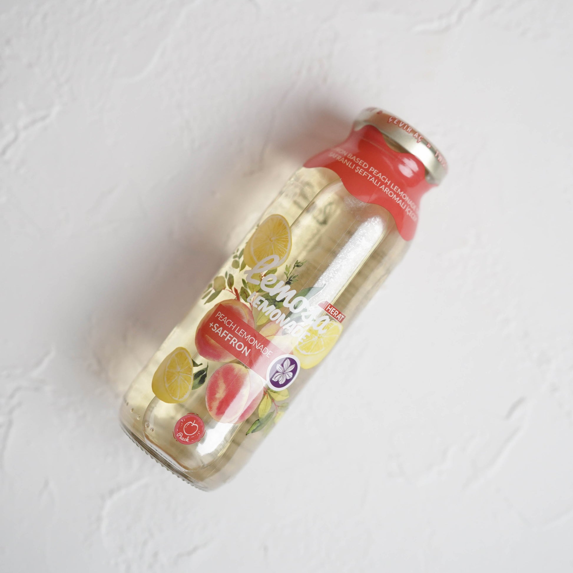 Bottle of juice with a red label on a light gray background