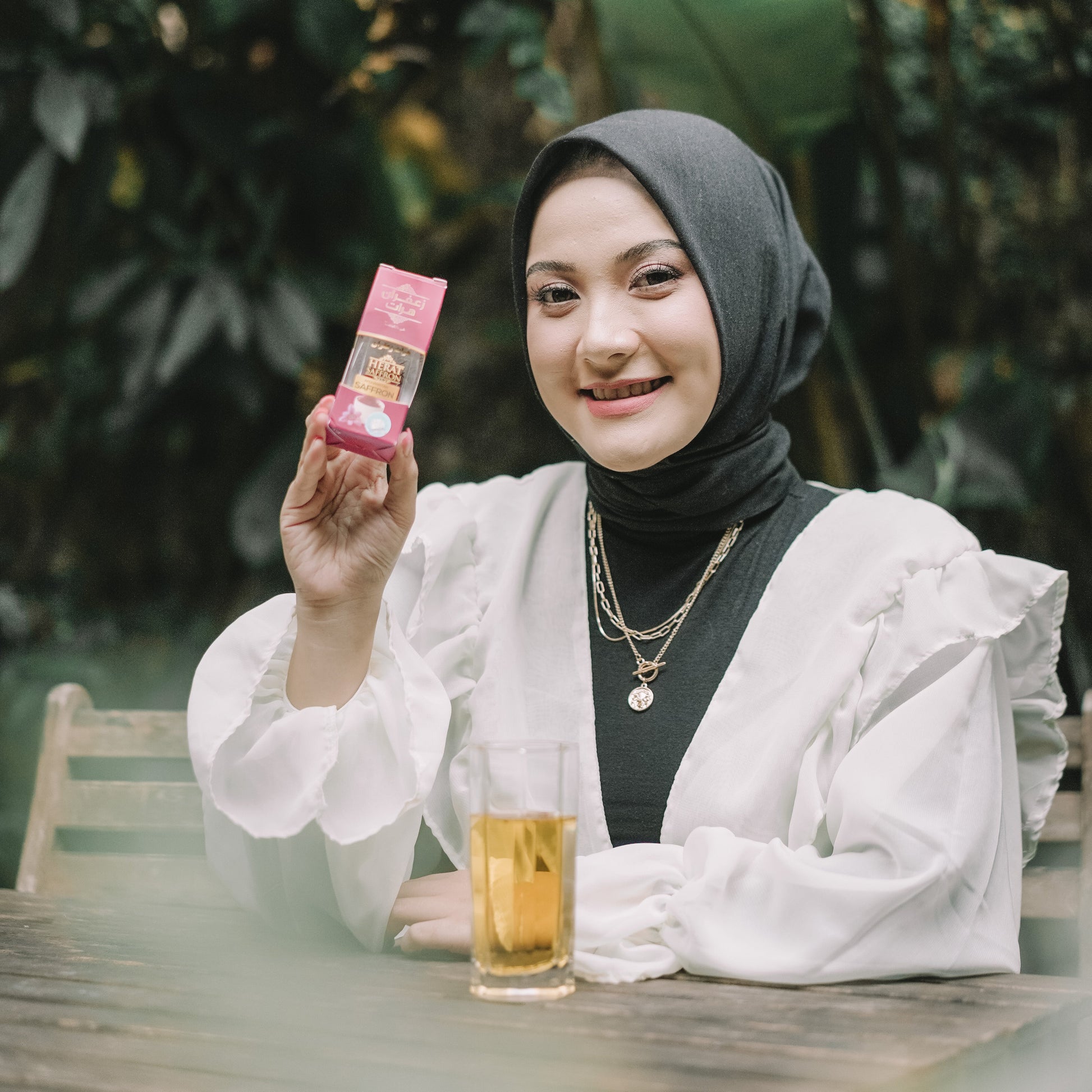 Woman holding a pink product in a natural setting