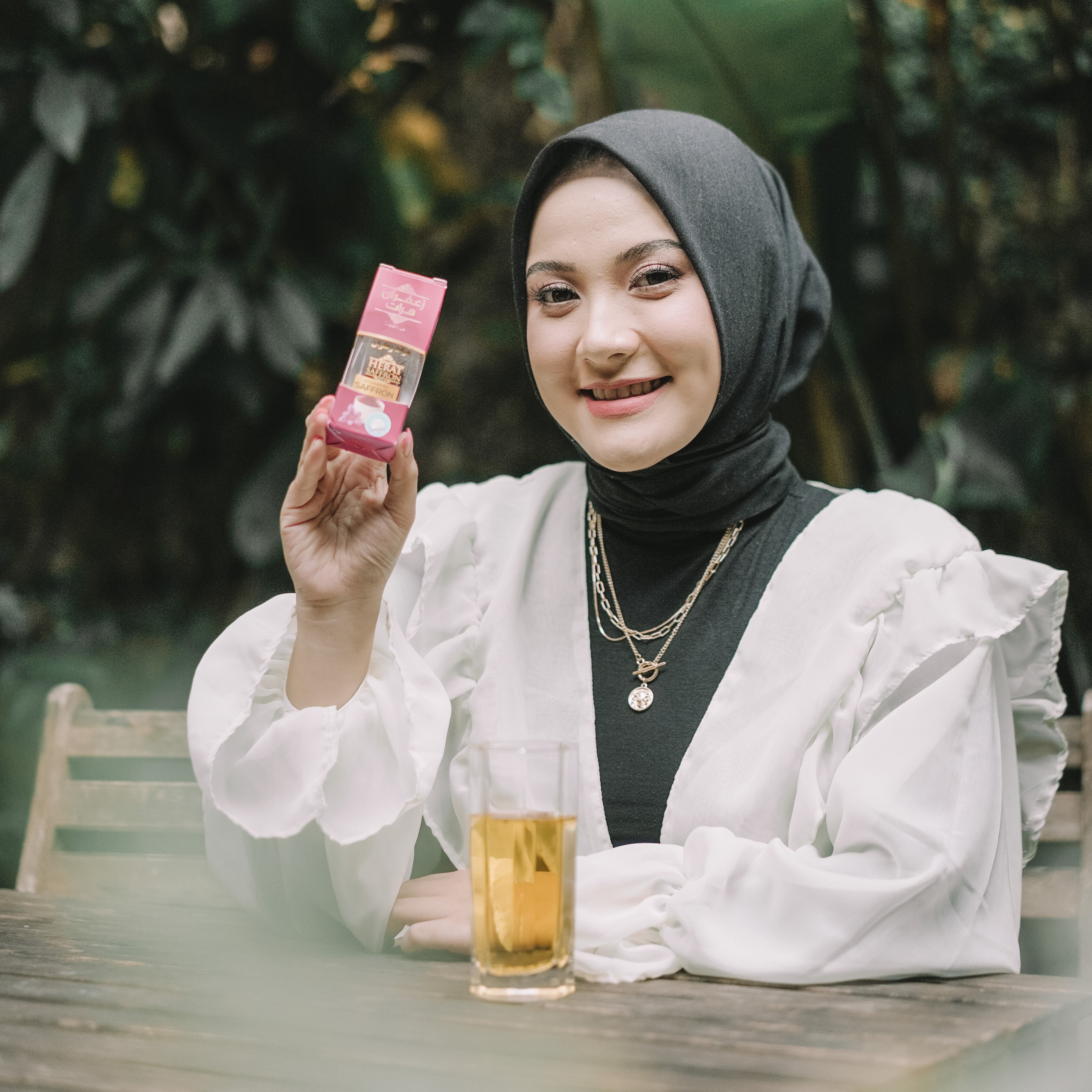 Woman holding a pink product in a natural setting