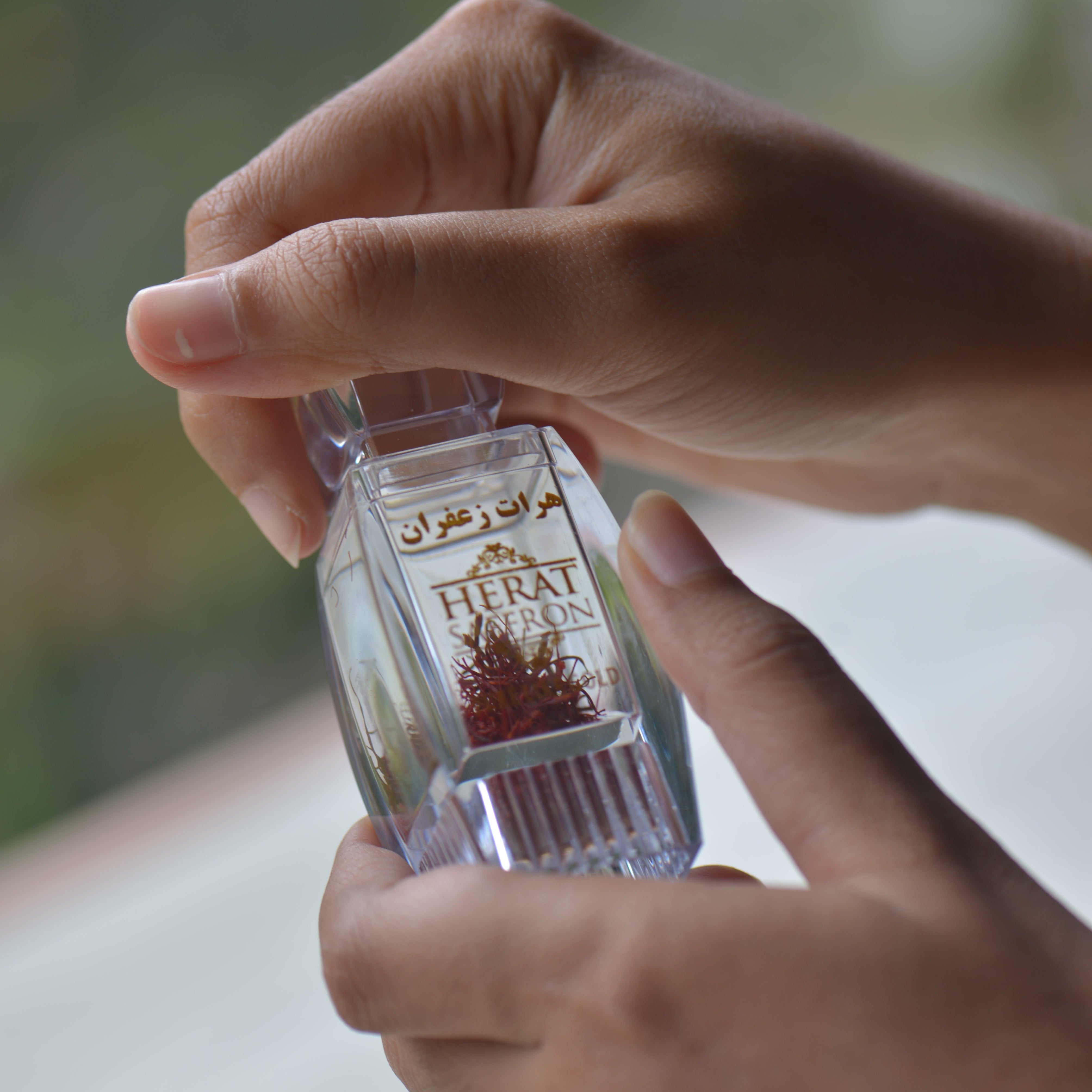 Close-up of hands holding a small bottle with a blurred background