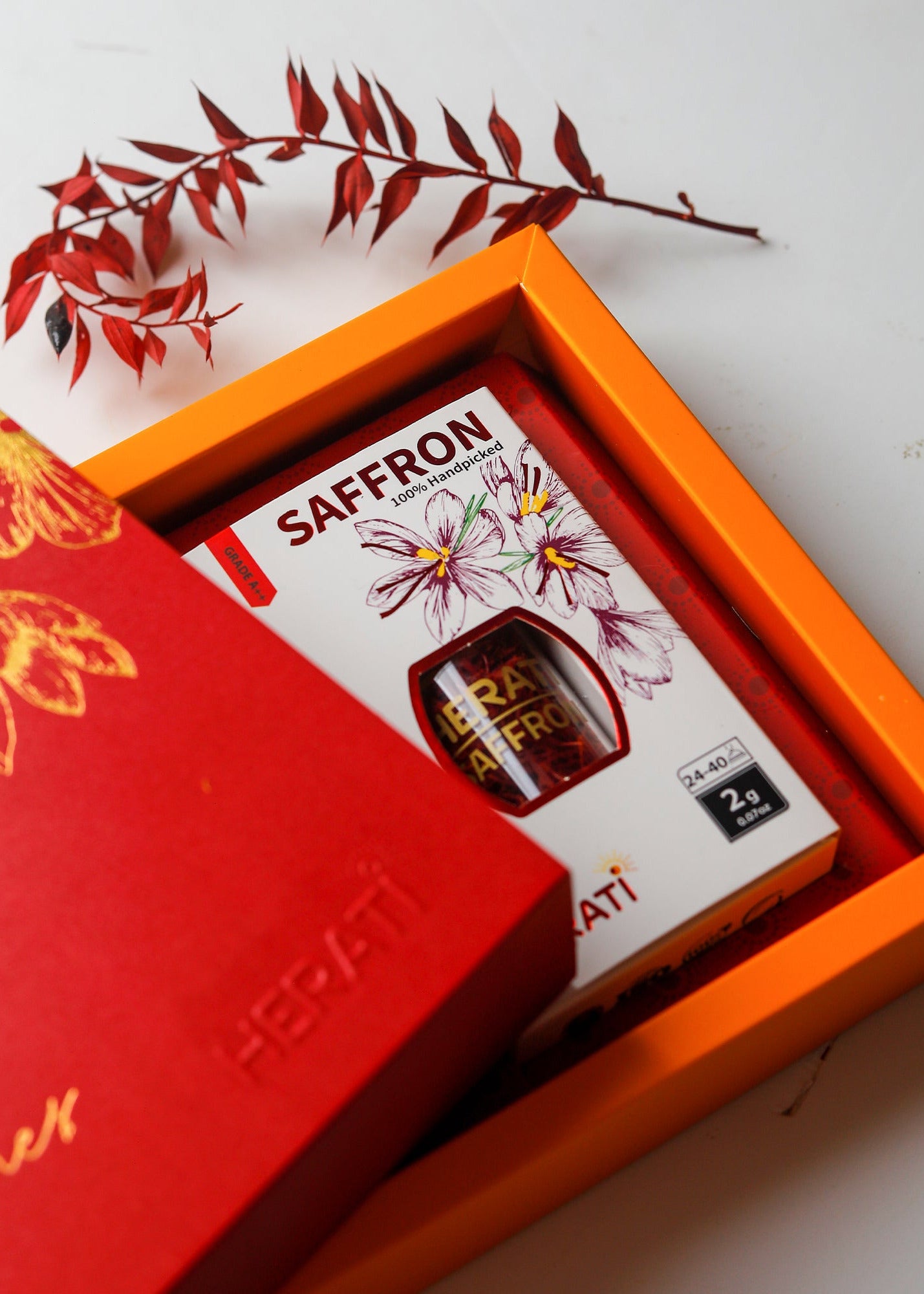 Saffron package in an orange box with a red floral design on a white background
