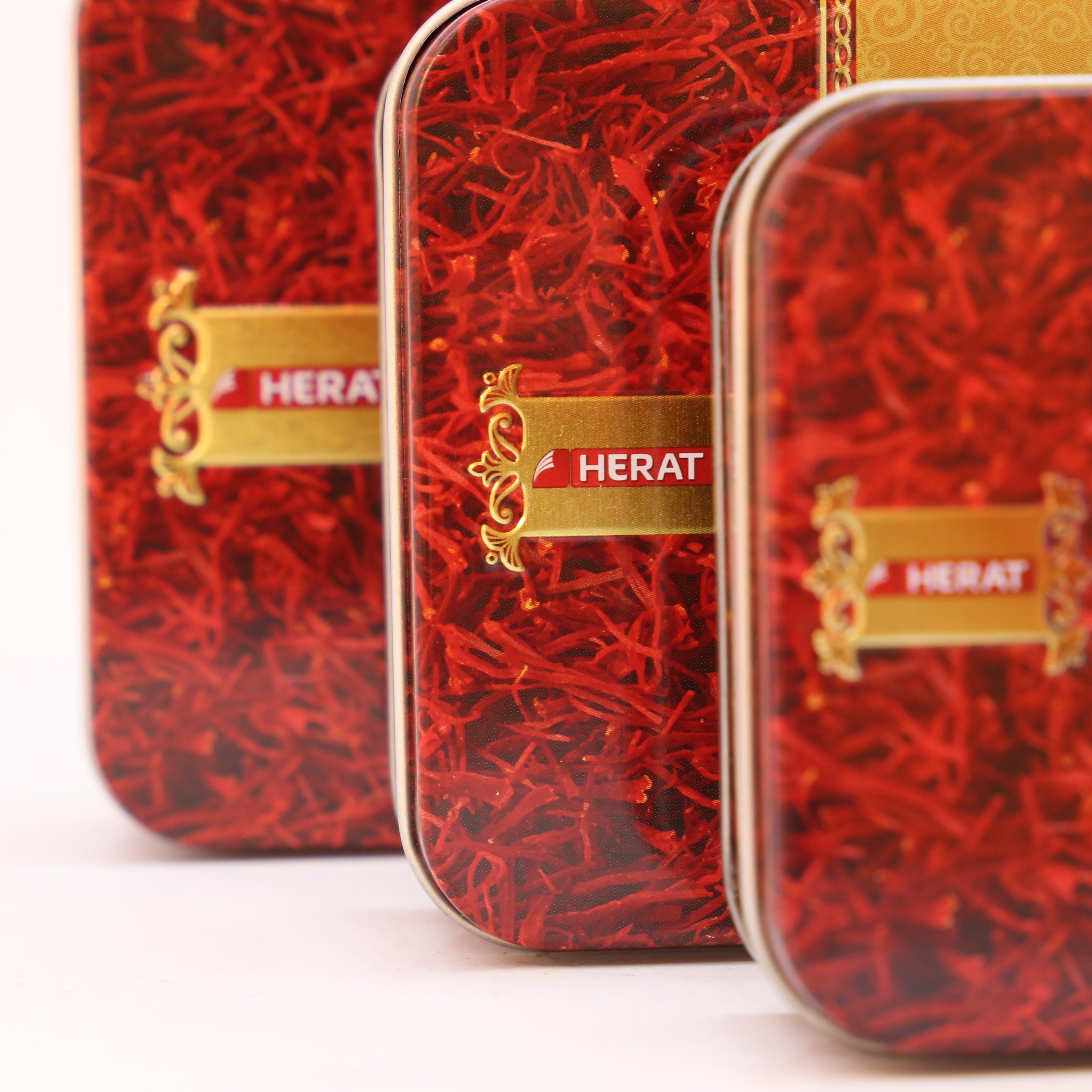 Red and gold tins with 'Herat' branding on a white background