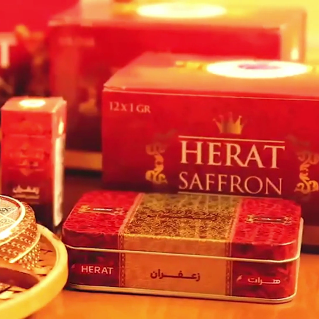 HERAT Saffron packaging on a table with saffron strands.